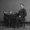 1877 gelingt es Edison, die menschliche Stimme aufzunehmen und wieder abzuspielen. Sein Aufnahme- und Abspielgerät besteht aus einer Stahlwalze. Er nennt es Phonograph. Das erste bezeugte „konservierte Wort“ der Welt ist „hello“. (Edison mit Phonograph/Wikimedia)